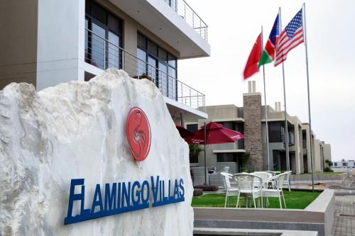 a sign on a rock in front of a building at Flamingo Villas Boutique Hotel in Walvis Bay