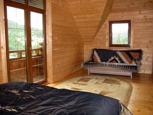 a room with a bed and a bench in a cabin at Kazkova Sadyba in Slavske