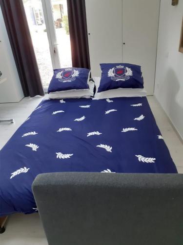 a bed with blue comforter and pillows on it at Manoir de l'As de Trèfle in Isneauville