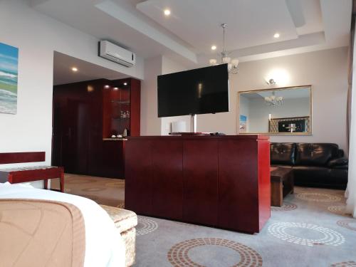 a living room with a flat screen tv on a cabinet at Flamingo Villas Boutique Hotel in Walvis Bay