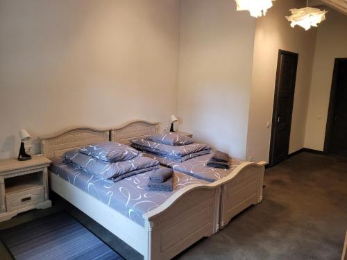 a bedroom with a bed with blue sheets and pillows at Vārves Muiža in Vārve