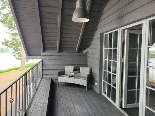 a porch with a couch and a chair on a deck at Vārves Muiža in Vārve
