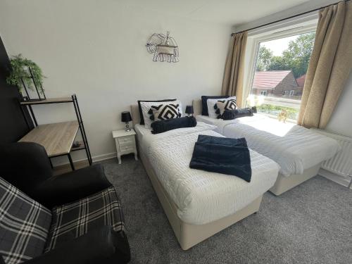 a bedroom with two beds and a window at Elite 47 Stays in Newcastle upon Tyne
