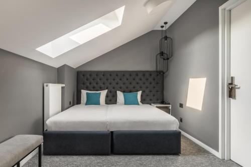 Un dormitorio con una cama grande con almohadas azules. en City Inn Lviv Smart Hotel, en Leópolis