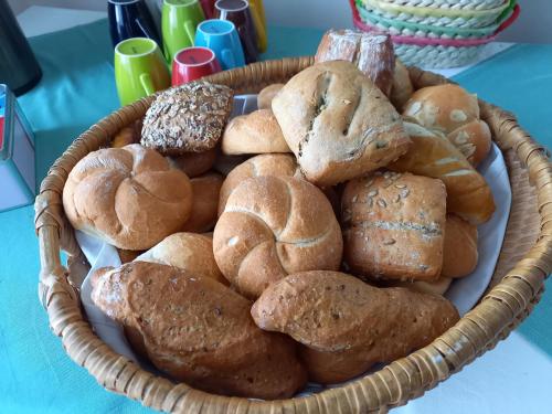 a basket filled with different types of bread on a table at Hotel Garni Haus am Wald in Reifnitz