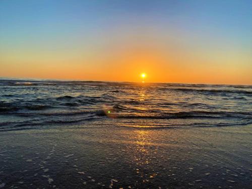 a sunset on a beach with the ocean at Hostal Los Mellizos in Conil de la Frontera