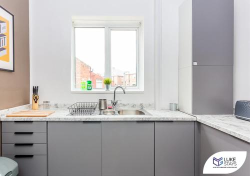 a white kitchen with a sink and a window at Luke Stays - Kitchener Street in Sheriff Hill