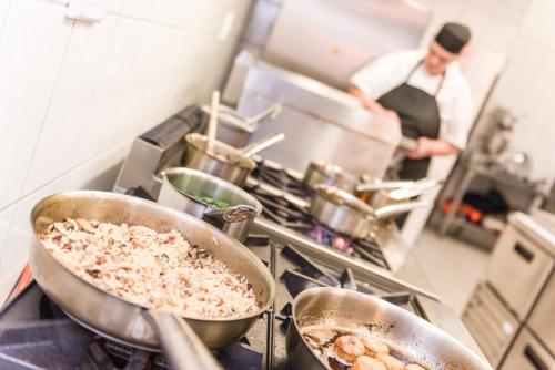 a kitchen with three pots of food on a stove at Flamingo Villas Boutique Hotel in Walvis Bay