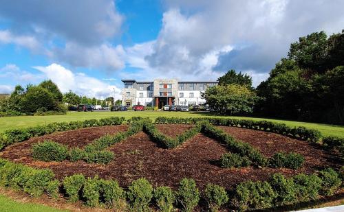 a garden in front of a large building at Menlo Park Hotel in Galway