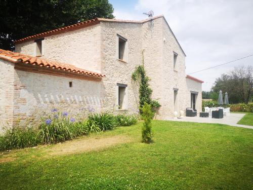a large stone building with a grass yard at Mas Puig in Saint-Genis-des-Fontaines
