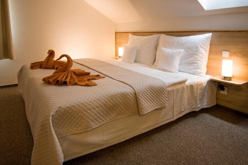 a bedroom with a large white bed with leaves on it at Pension Libá in Libá