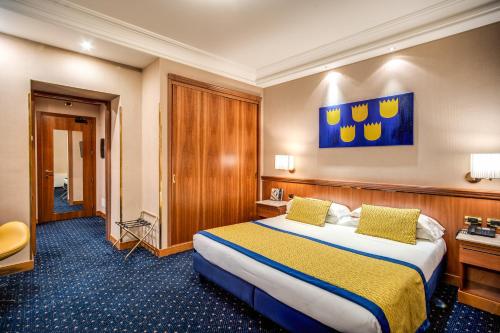 a hotel room with a bed and a painting on the wall at Hotel Diocleziano in Rome