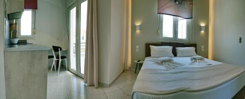 a bedroom with a bed and a kitchen with windows at Edem in Vatera