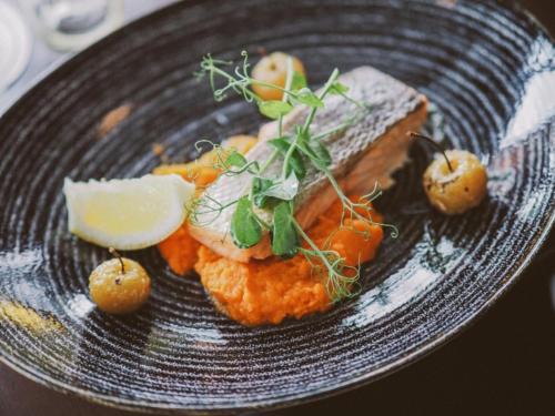 a plate of food with fish and vegetables on it at Menlo Park Hotel in Galway