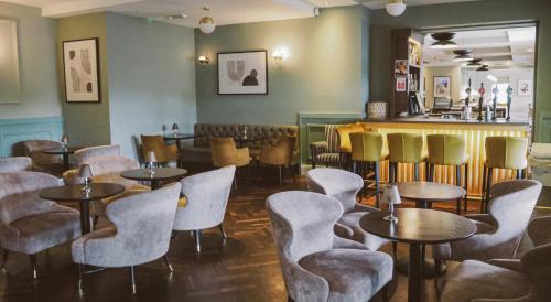 um restaurante com mesas e cadeiras e um bar em Menlo Park Hotel em Galway