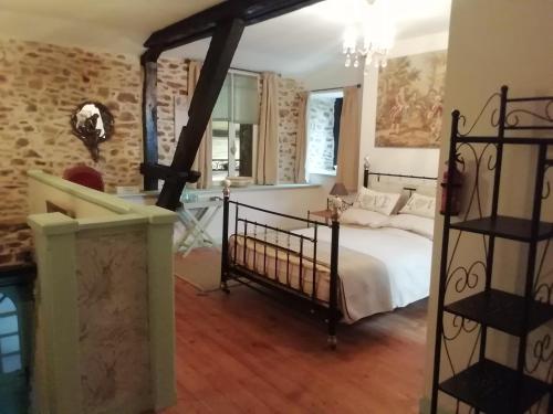 sypialnia z łóżkiem i ceglaną ścianą w obiekcie The Old Cider Press w mieście Carnoët