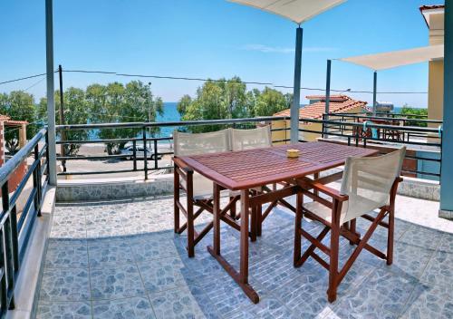 a wooden table and chairs on a balcony at Edem in Vatera