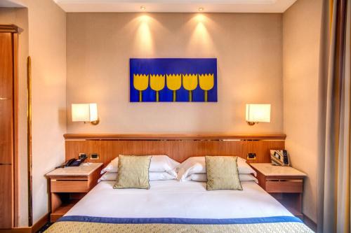 a bedroom with a bed with two nightstands and a painting at Hotel Diocleziano in Rome