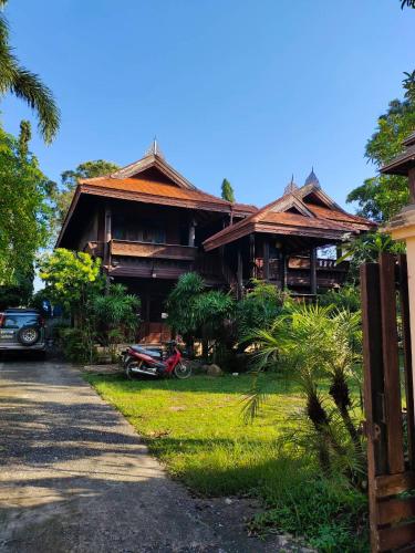 a house with a motorcycle parked in front of it at Fueangfu Villa Chaweng in Chaweng