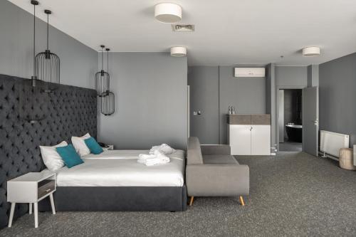 a bedroom with a bed and a couch and a chair at City Inn Lviv Smart Hotel in Lviv