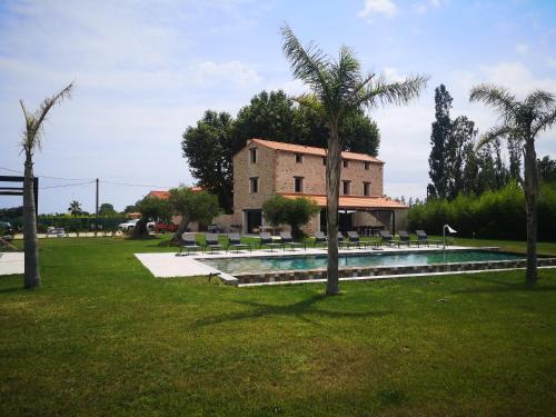 une maison avec une piscine et des palmiers dans l'établissement Mas Puig Grand Gîte, à Saint-Génis