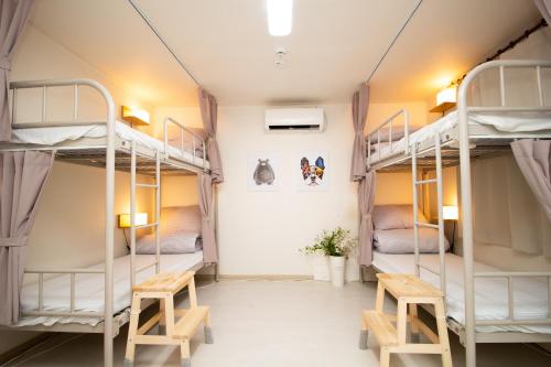 a room with three bunk beds and two benches at YAB-GuestHouse, FemaleOnly, ForeignOnly in Seoul