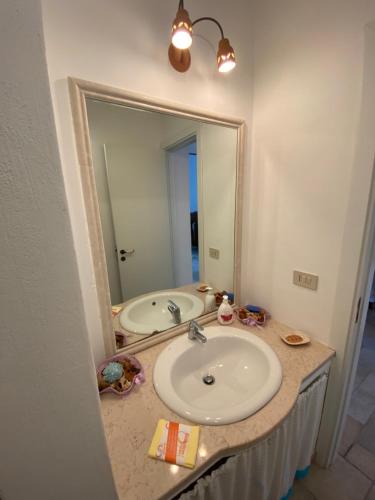 a bathroom with a sink and a large mirror at Casa Corallo in Peschici