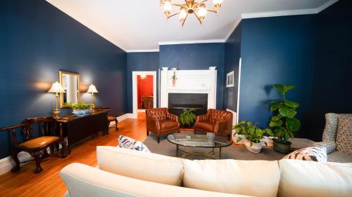 un soggiorno con pareti blu e un divano bianco di The Edenton Collection-Captain's Quarters Inn a Edenton