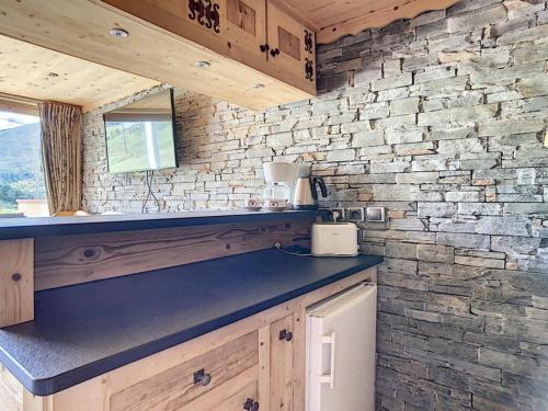 une cuisine avec un comptoir et un mur en briques dans l'établissement Duplex rénové · Départ ski aux pieds · Balcon · 45 m² · 6 pers · 3 flocons Or - FR-1-344-186, aux Menuires