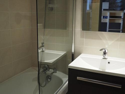 La salle de bains est pourvue d'une douche, d'un lavabo et d'une baignoire. dans l'établissement Studio rénové proche des pistes avec balcon - Tout équipé, 3 pers., 2 flocons or - FR-1-344-180, aux Menuires