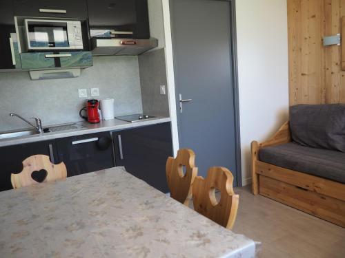 une petite cuisine avec une table et un canapé dans l'établissement Studio rénové proche des pistes avec balcon - Tout équipé, 3 pers., 2 flocons or - FR-1-344-180, aux Menuires