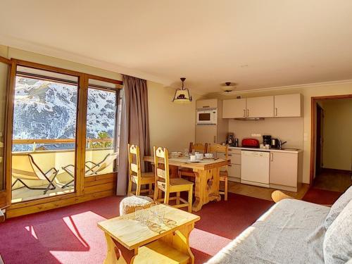 Il comprend une cuisine et un salon avec une table, une cuisine et une salle à manger. dans l'établissement Bel appartement rénové 2 pièces proche des pistes avec balcon, sauna, hammam et WIFI - FR-1-344-145, aux Menuires