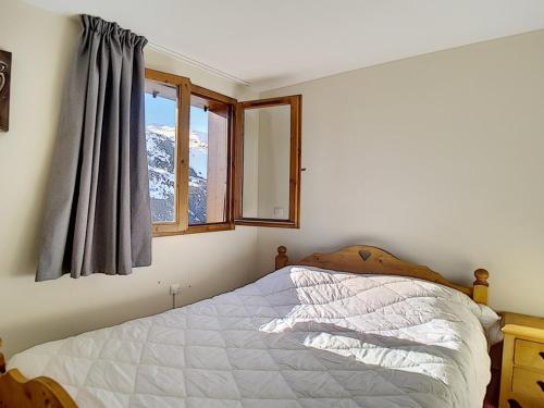 a bedroom with a bed with a view of a mountain at Bel appartement rénové 2 pièces proche des pistes avec balcon, sauna, hammam et WIFI - FR-1-344-145 in Les Menuires