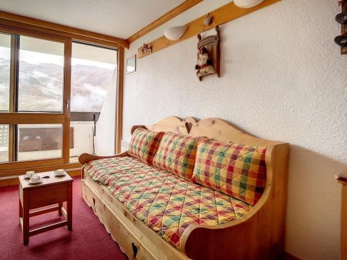 - un canapé dans une pièce avec fenêtre dans l'établissement Studio duplex lumineux, départ et retour ski aux pieds, balcon ensoleillé, idéal pour 4 pers. - FR-1-344-257, aux Menuires