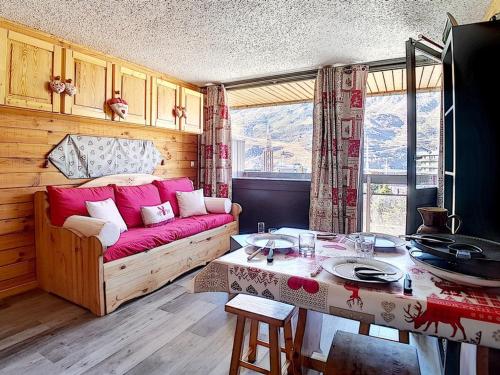 un salon avec un canapé et une table dans l'établissement Studio entièrement rénové Centre station Balcon - FR-1-344-607, aux Menuires