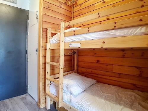 - deux lits superposés dans une chambre en bois dans l'établissement Studio entièrement rénové Centre station Balcon - FR-1-344-607, aux Menuires