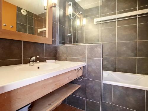 une salle de bain avec un lavabo et une baignoire dans l'établissement Bel Appartement Rénové de 62 m², 8 Pers, Pieds des Pistes, Parking Couvert Inclus - Les Bruyères - FR-1-344-345, aux Menuires