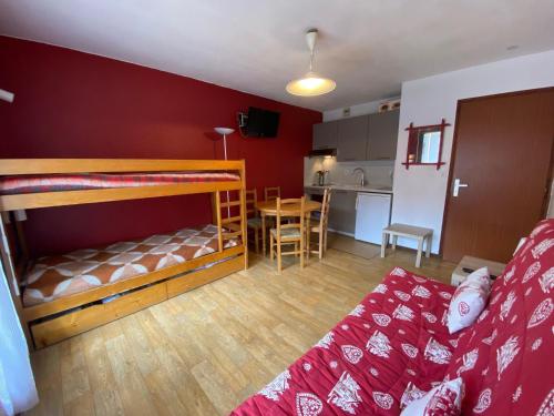 a room with two bunk beds and a kitchen at Studio La Clusaz, 1 pièce, 4 personnes - FR-1-459-67 in La Clusaz