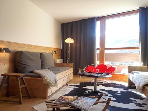 un salon avec un canapé et une grande fenêtre dans l'établissement DUPLEX rénové · 8 pers · Pied des pistes · 2 balcons · Wifi - FR-1-344-427, aux Menuires