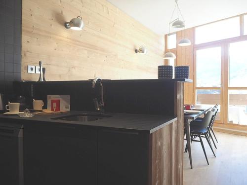 une cuisine avec un évier et une table avec des chaises dans l'établissement DUPLEX rénové · 8 pers · Pied des pistes · 2 balcons · Wifi - FR-1-344-427, aux Menuires