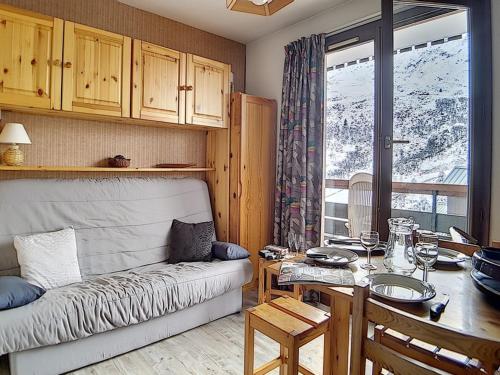 un salon avec un canapé et une table dans l'établissement Studio fonctionnel proche des pistes avec balcon - FR-1-344-535, aux Menuires