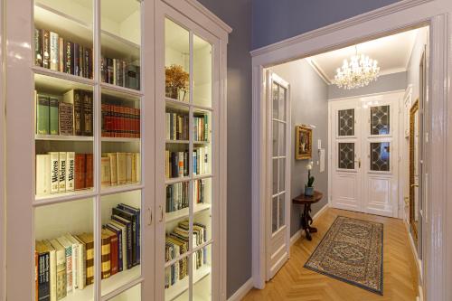 a hallway with book shelves filled with books at Tabán Art Appartmann in Budapest