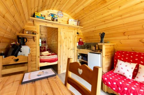 Cette chambre dispose d'une cabine en bois avec un canapé rouge. dans l'établissement Le Cocoon Asniérois, à Asnières-sur-Vègre