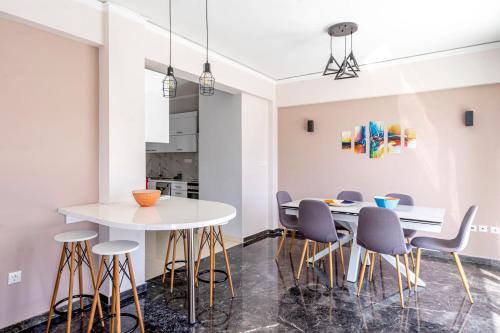 a dining room with a white table and chairs at Penthouse in the heart of Athens / Koukaki area in Athens