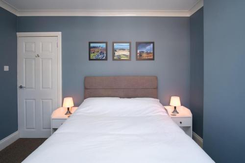 een slaapkamer met een groot bed met 2 lampen bij NEW 2BD Victorian Terraced House Loughborough in Loughborough