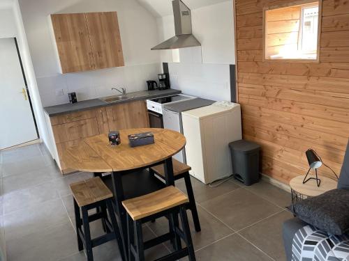 une petite cuisine avec une table et un réfrigérateur dans l'établissement La petite longère, à Hillion