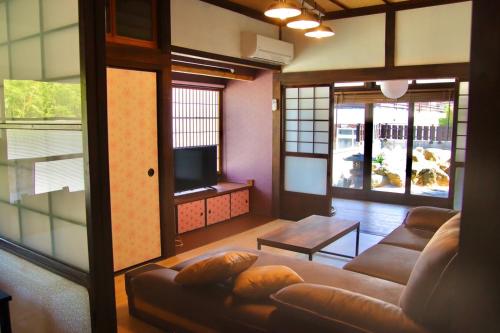 een woonkamer met een bank en een tv bij ドッグラン併設 しまなみ御殿 in Imabari