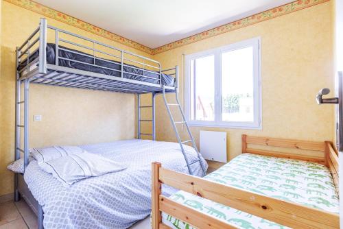 a bedroom with two bunk beds and a window at La Granja - Maison avec cheminée, jardin, baby-foot in Formiguères