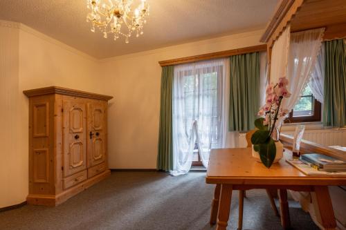 a living room with a table and a window at Zur Margarethenmühle - Landgasthof und Waldhotel in Döbeln