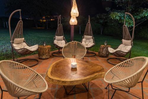 a group of chairs and a wooden table and chairs at Hotel Campestre Cafe Cafe in Montenegro